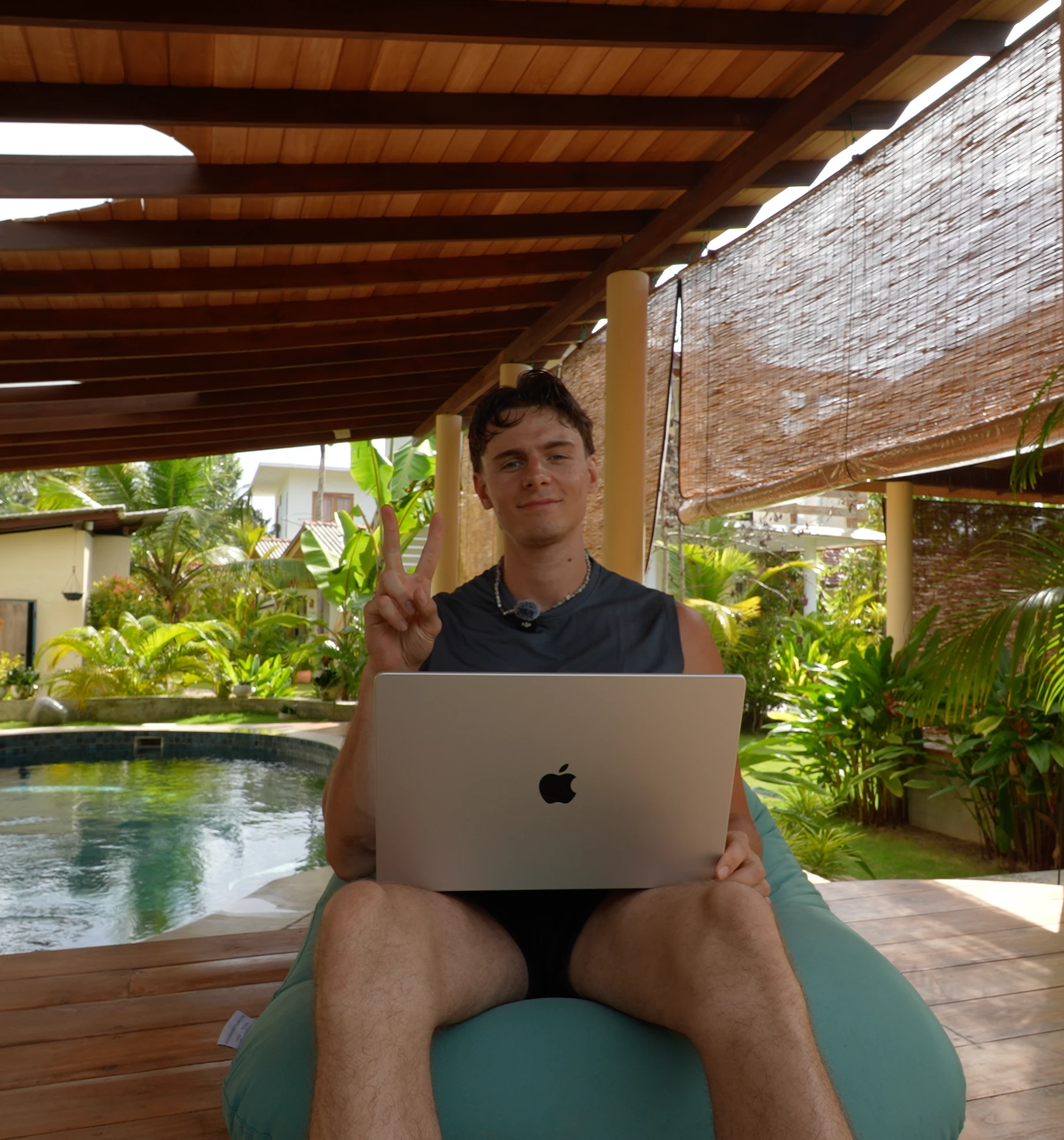 Odin am Pool, MacBook in der einen Hand, Peace-Zeichen mit der anderen